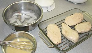 Cold chicken breasts that had been poached in butter, along with almost-set chaud-froid sauce ready to be applied.