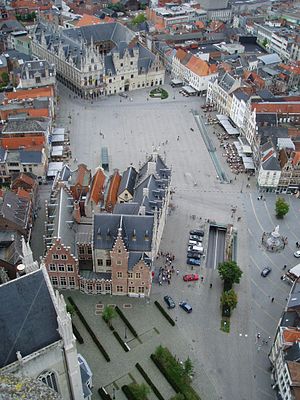 Aerial picture looking down at a town square in Belgium, with empty space, surrounded by buildings.