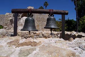(CC) Photo: Robert A. Estremo Two of the original bells (San Vicente and San Juan) sit on display within the footprint of the original bell tower at Mission San Juan Capistrano. Damage to the smaller bell (San Juan), sustained during the 1812 earthquake, is readily apparant in this view.
